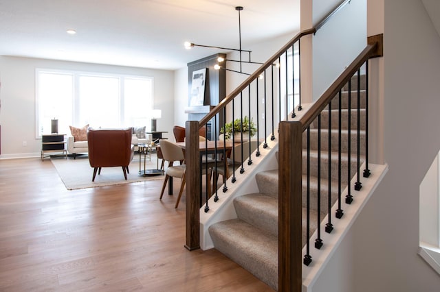 stairway with a chandelier and hardwood / wood-style floors