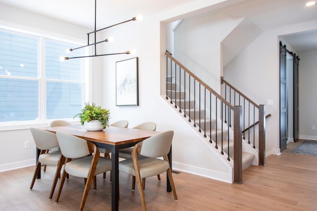 dining area with light wood-type flooring and a chandelier