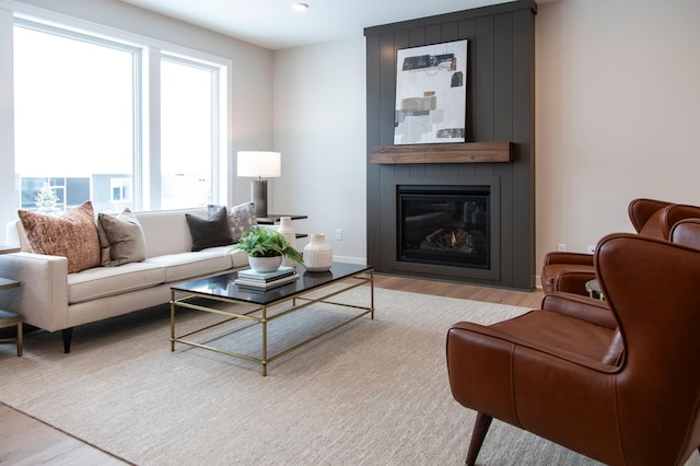 living room with light hardwood / wood-style floors and a large fireplace