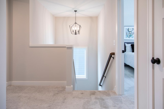 stairway featuring a chandelier and carpet flooring