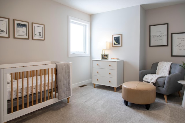 bedroom featuring light carpet and a crib