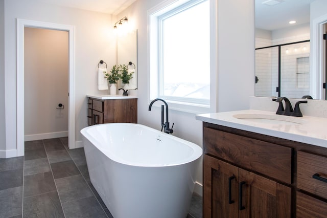 bathroom featuring vanity, separate shower and tub, and a healthy amount of sunlight