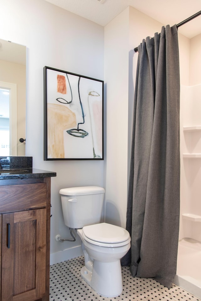 bathroom with toilet, vanity, and curtained shower