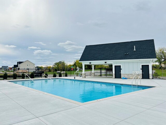 pool with a patio area and fence