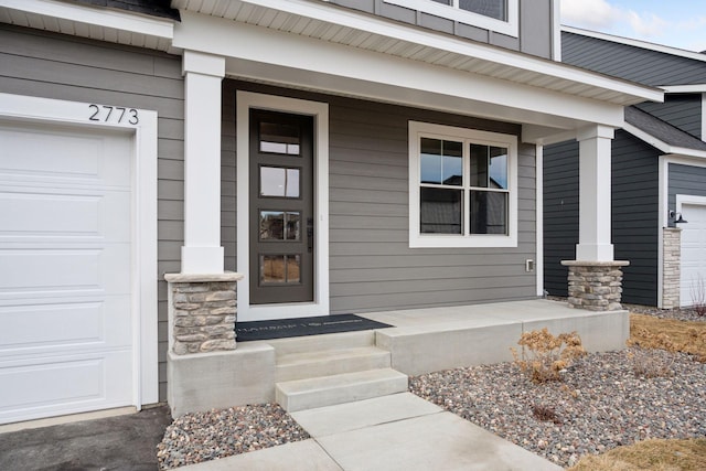 entrance to property with a porch and an attached garage