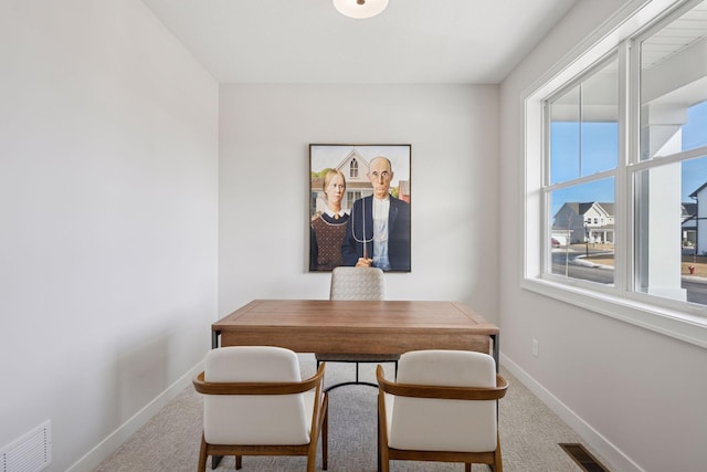 carpeted dining room with baseboards and visible vents