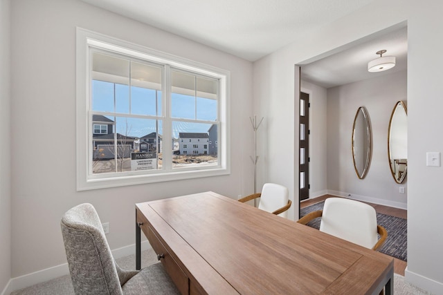 dining area featuring carpet flooring and baseboards