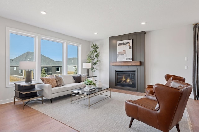 living room with baseboards, a fireplace, wood finished floors, and recessed lighting