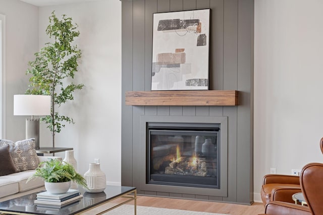 living area with a large fireplace and wood finished floors