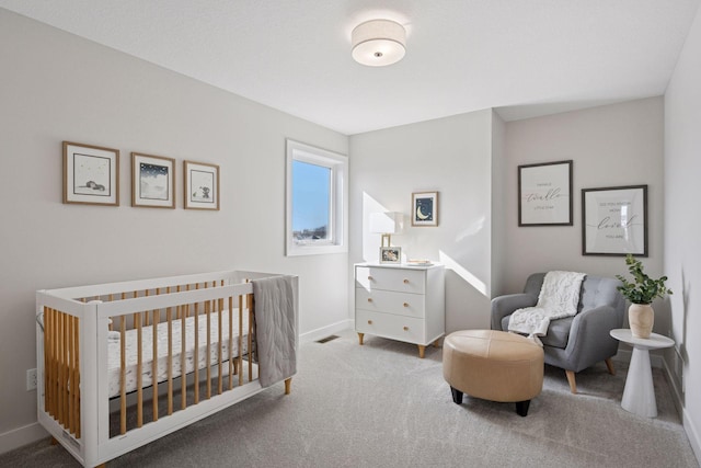 bedroom with a nursery area, carpet, visible vents, and baseboards