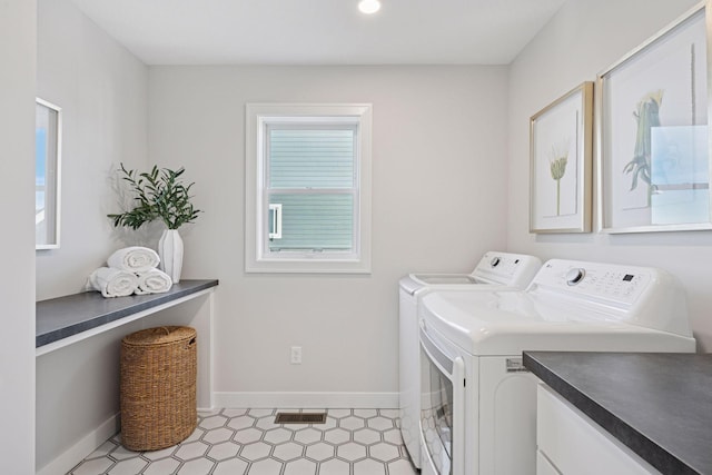 washroom with washing machine and dryer, visible vents, and baseboards