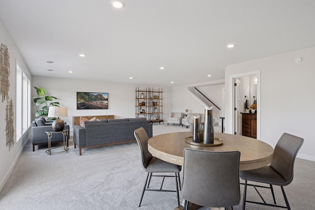 dining space with recessed lighting, light carpet, and baseboards