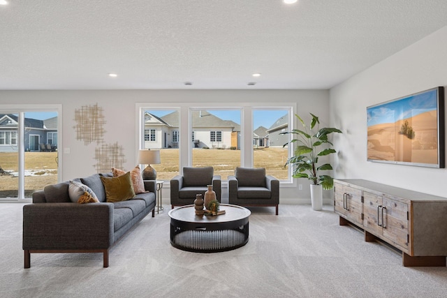 carpeted living room featuring a textured ceiling and recessed lighting