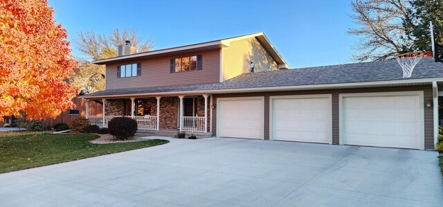 front of property with a garage, a front yard, and covered porch