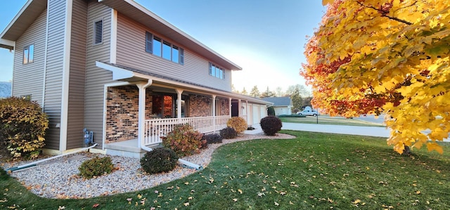 view of home's exterior with a yard, covered porch, and a garage