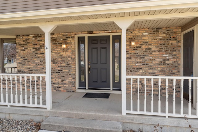 view of exterior entry featuring covered porch