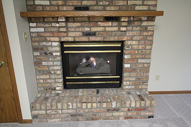 room details featuring a brick fireplace and carpet flooring