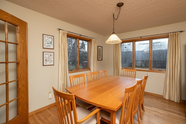 dining area featuring a textured ceiling and light wood-type flooring