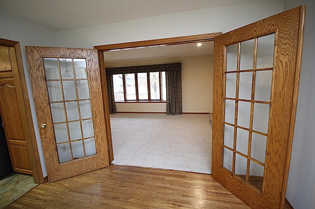 hall featuring a textured ceiling and light wood-type flooring