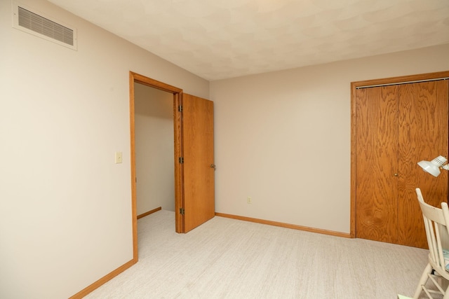 unfurnished bedroom with light carpet and a closet