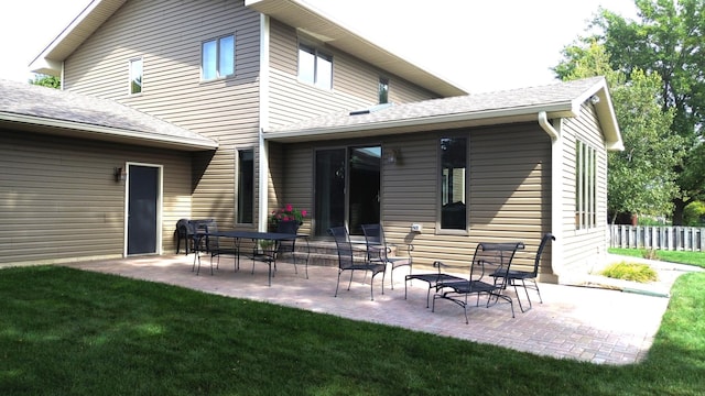 rear view of house with a lawn and a patio