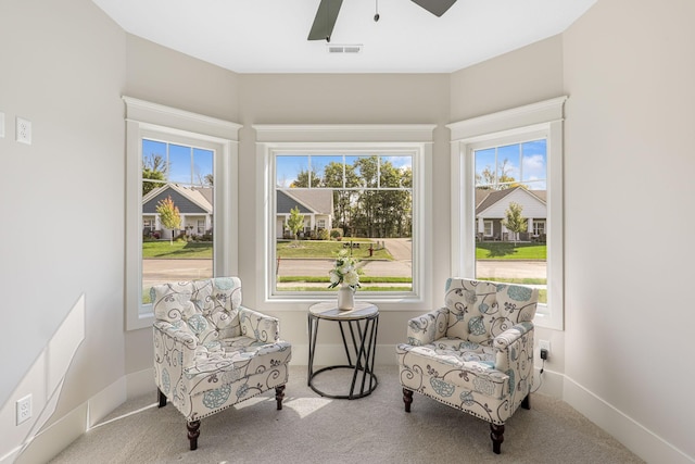 sitting room with ceiling fan and light carpet