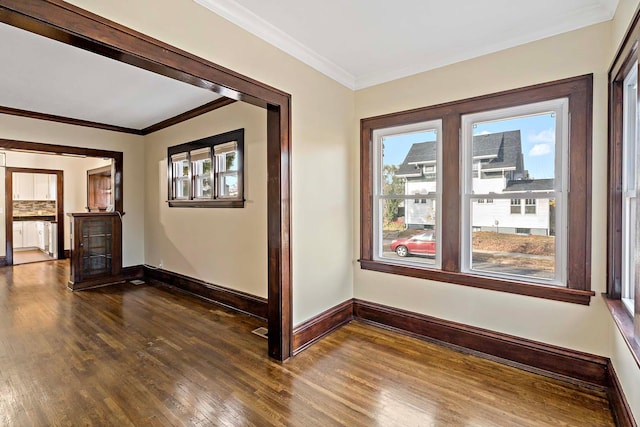 spare room featuring ornamental molding and dark wood-type flooring