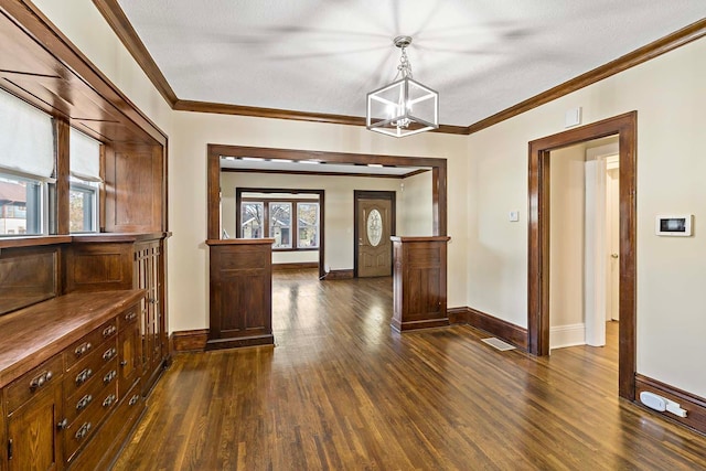 unfurnished dining area featuring a textured ceiling, ornamental molding, and dark hardwood / wood-style floors