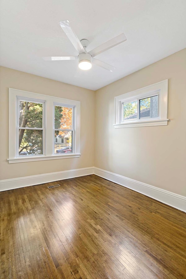 unfurnished room featuring ceiling fan, a healthy amount of sunlight, and wood-type flooring