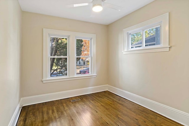 unfurnished room featuring dark wood-type flooring and ceiling fan