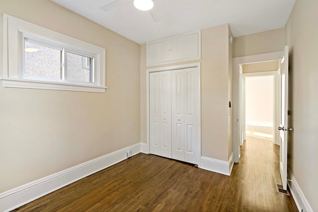 unfurnished bedroom featuring a closet, dark hardwood / wood-style floors, and ceiling fan