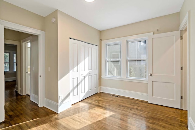 interior space with a closet, multiple windows, and hardwood / wood-style floors