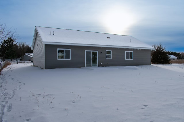 view of snow covered rear of property