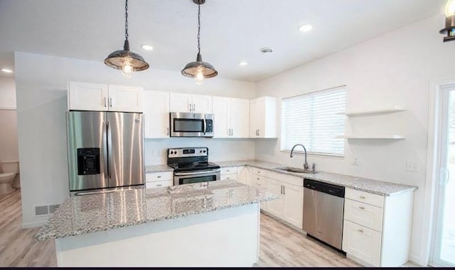 kitchen with white cabinets, appliances with stainless steel finishes, sink, and pendant lighting