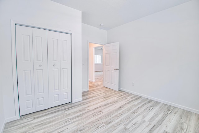 unfurnished bedroom featuring a closet and light hardwood / wood-style flooring