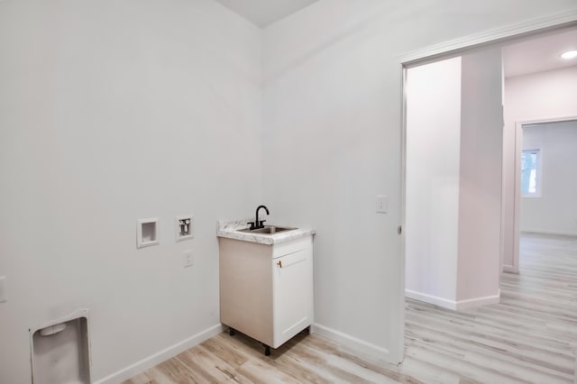 laundry area with sink, hookup for a washing machine, and light wood-type flooring