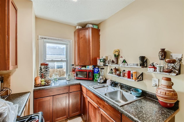 kitchen featuring a textured ceiling and sink