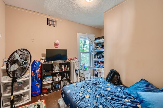 bedroom with a textured ceiling and dark hardwood / wood-style flooring