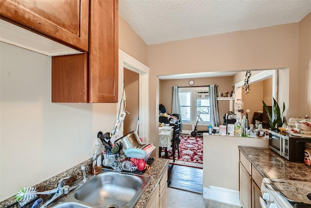 kitchen with a textured ceiling, range, and light tile floors