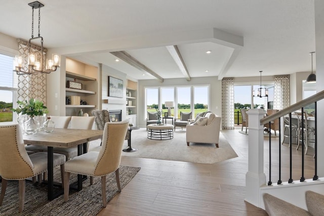 dining room with light hardwood / wood-style floors, a notable chandelier, and beamed ceiling