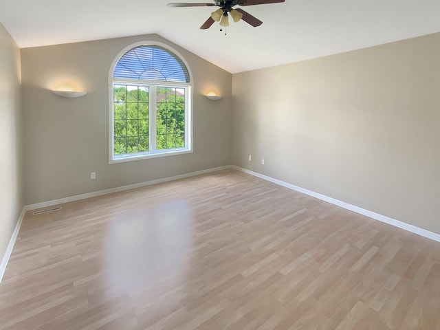 spare room with ceiling fan, light hardwood / wood-style floors, and vaulted ceiling