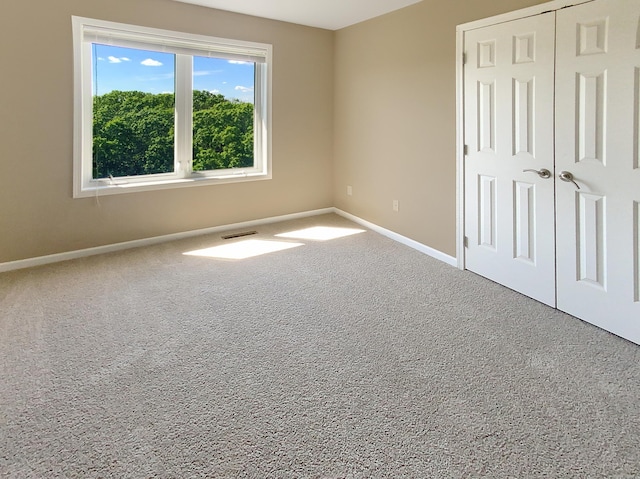 unfurnished bedroom featuring carpet flooring and a closet