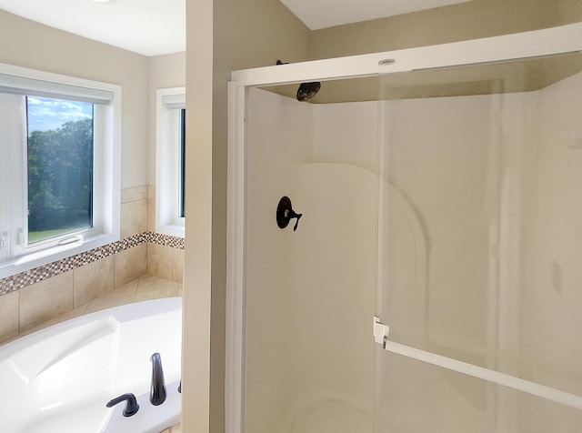 bathroom featuring a healthy amount of sunlight and shower with separate bathtub