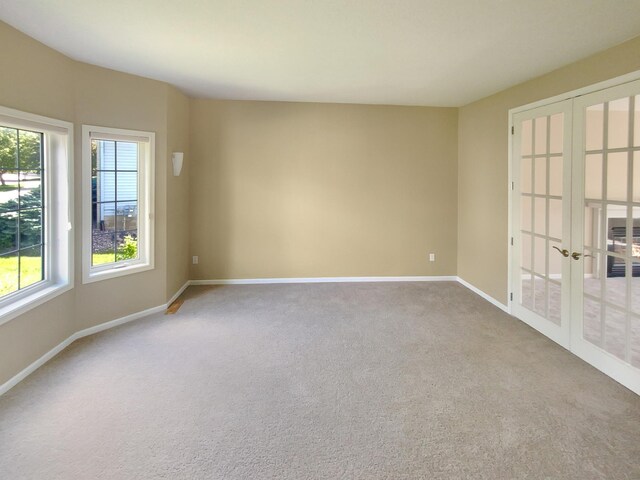 carpeted empty room featuring french doors