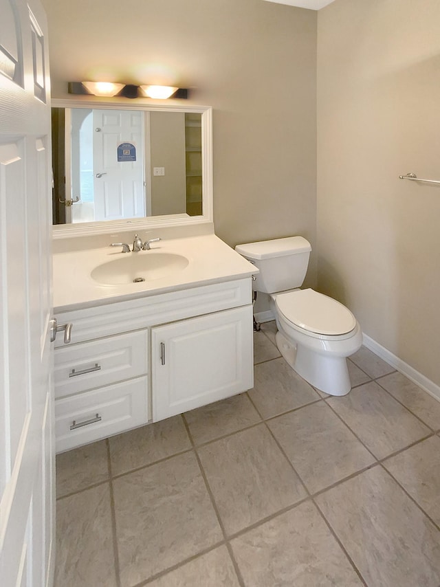 bathroom featuring tile patterned flooring, toilet, and vanity