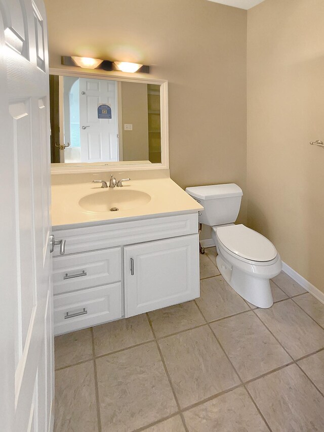 bathroom with tile patterned flooring, toilet, and vanity