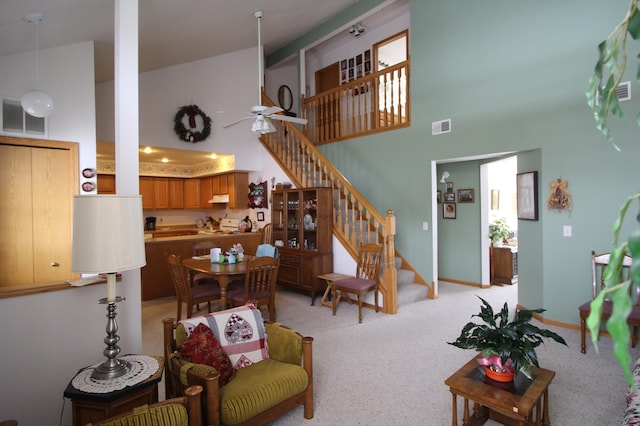 carpeted living room with a towering ceiling and ceiling fan