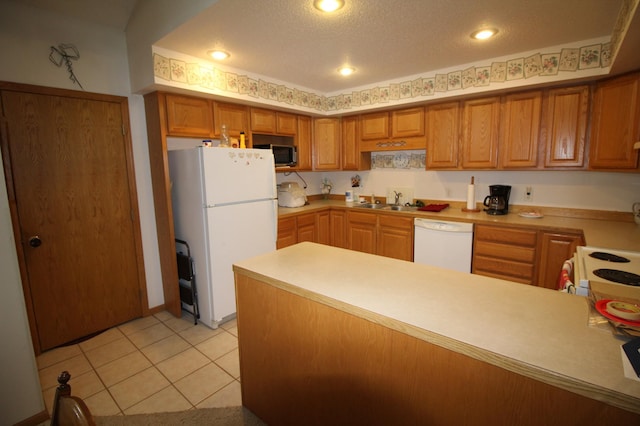 kitchen featuring sink, white appliances, light tile flooring, and a textured ceiling