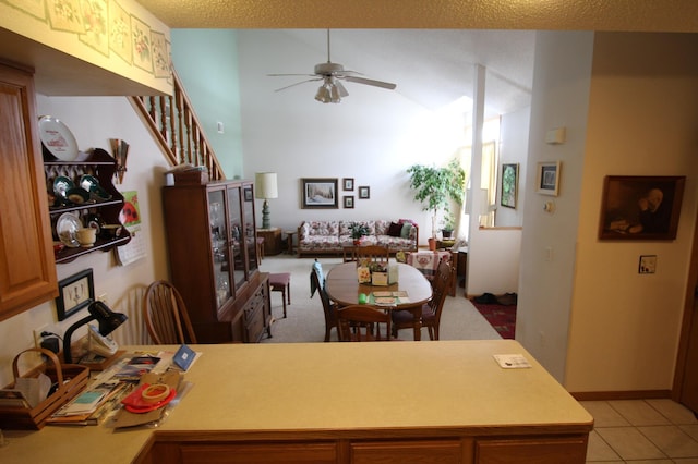 dining space featuring lofted ceiling, ceiling fan, and light tile flooring