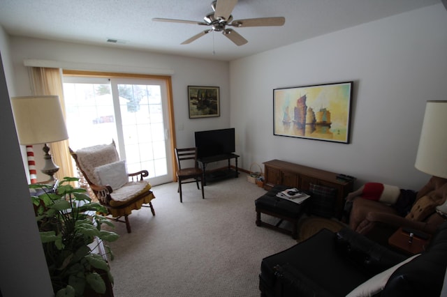 carpeted living room with ceiling fan